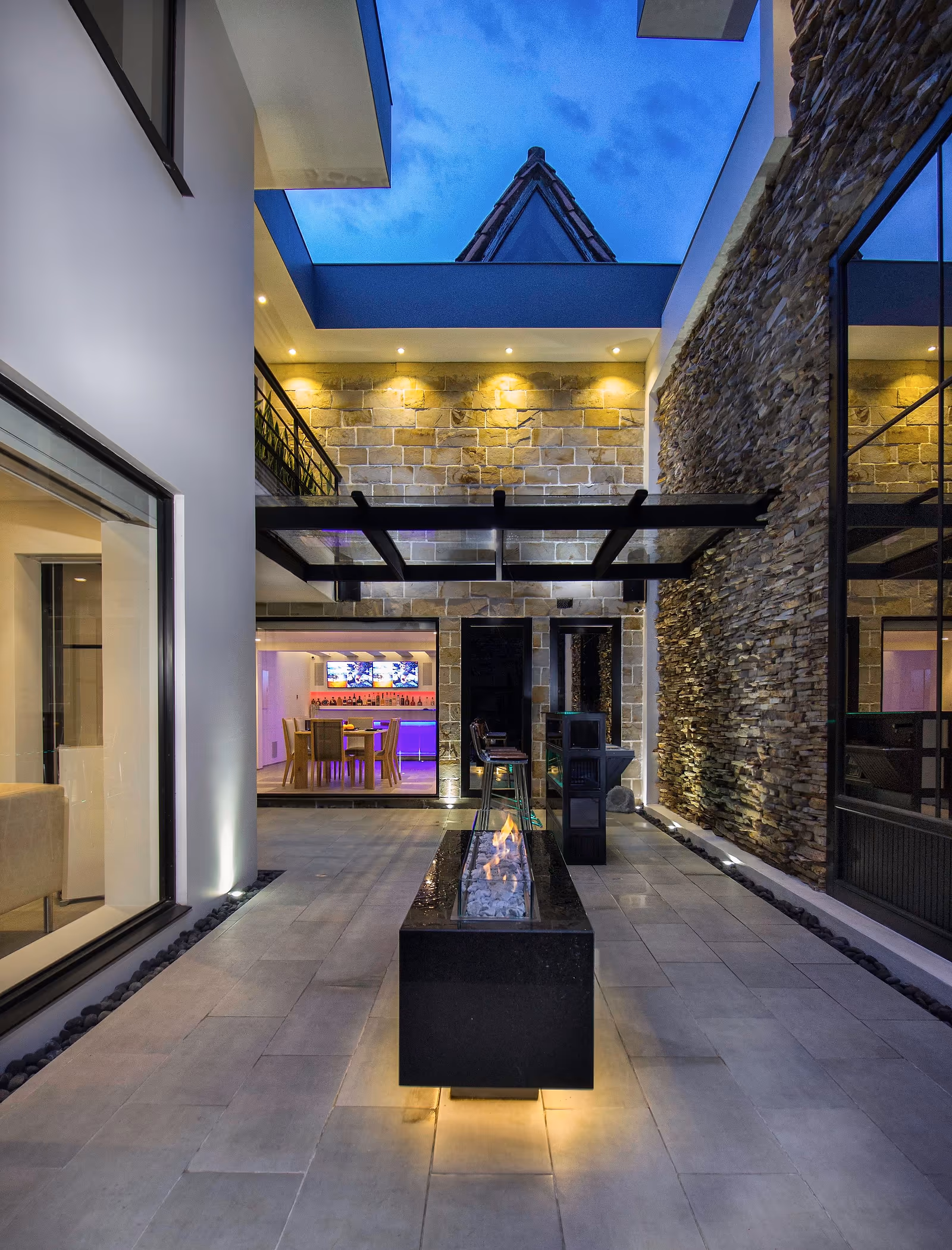 Evening courtyard illuminated with warm architectural lighting and carefully controlled atmosphere.